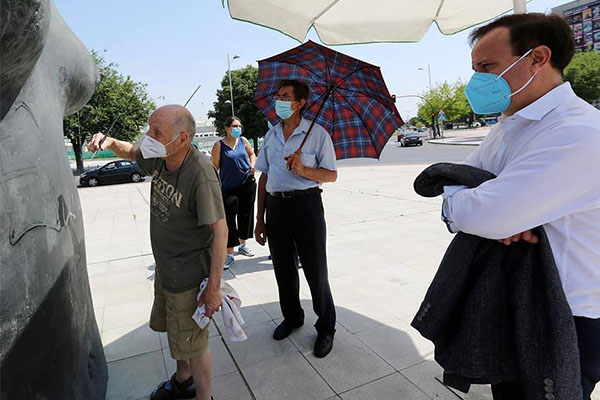 Antonio López arregla su escultura. Miembros del Ayuntamiento presentes