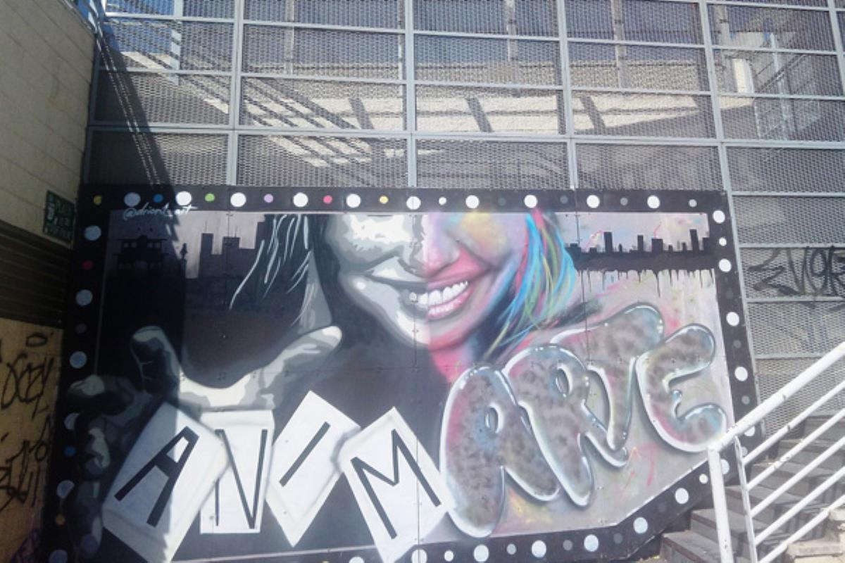 Dos participantes de `Muros Vivos´ dejan sus graffitis en la fachada