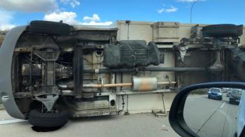 Un camión vuelca en mitad de la carretera