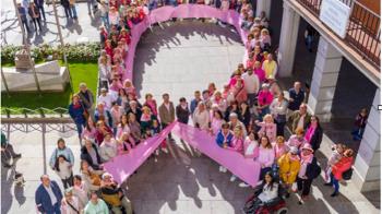 Un gran lazo humano rosa en la Plaza Mayor como muestra de apoyo a las mujeres que sufren esta enfermedad 