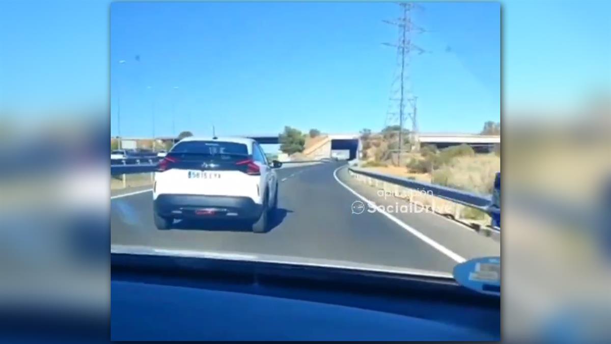 Un turismo circula por medio de la vía para no dejar adelantar