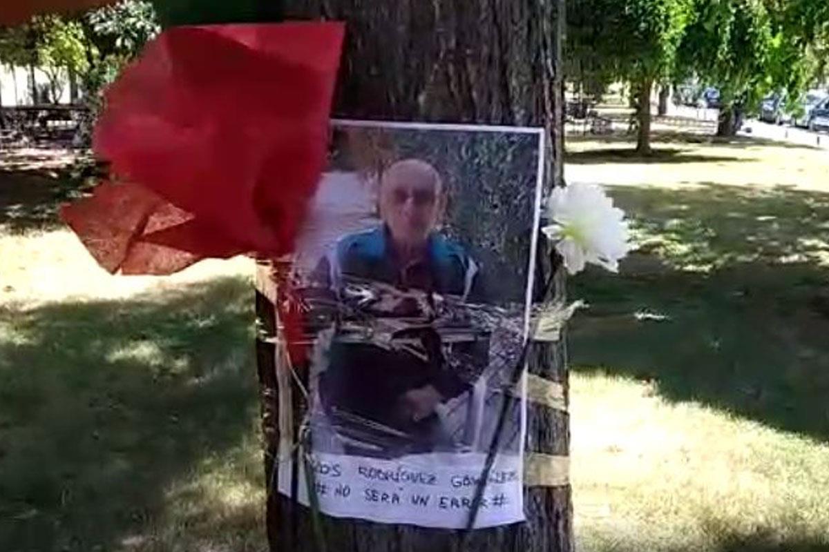 Entre lagrimas, familiares de residentes fallecidos colocan fotografías de los mayores en los árboles de los parques junto a mensajes y flores