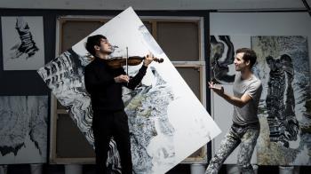 Un violinista y un pintor hace una performance musical